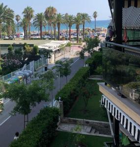 a view of a street with palm trees and the ocean at Salou Llevant parking gratuit in Salou