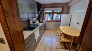 una cucina con tavolo in legno e pavimento in legno di Self-catering extended family home a Edimburgo