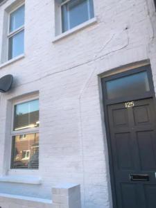 - un bâtiment en briques blanches avec une porte noire dans l'établissement Smart London Townhouse, à Londres
