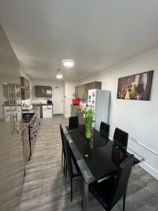 a dining room with a table and chairs and a kitchen at WoodGreen house in London