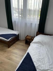 a bedroom with two beds and a window at Irys 1 in Tychy