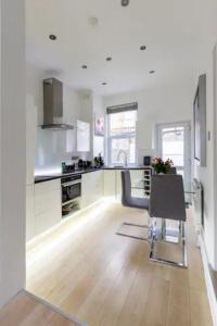 - une cuisine avec une table et une chaise dans la chambre dans l'établissement Smart London Townhouse, à Londres