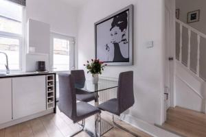 une salle à manger avec une table et des chaises en verre dans l'établissement Smart London Townhouse, à Londres