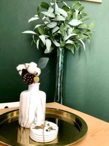 La salle de bains est pourvue d'un lavabo et d'un vase avec des fleurs blanches. dans l'établissement Appartement Cosy proche Futuroscope, à Jaunay-Clan