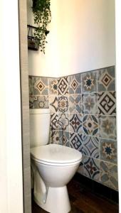 La salle de bains est pourvue de toilettes blanches et de carrelage. dans l'établissement Appartement Cosy proche Futuroscope, à Jaunay-Clan