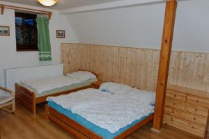two twin beds in a room with wooden floors at Rokytnice 434 in Rokytnice nad Jizerou