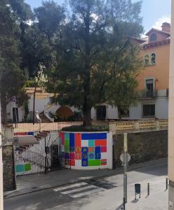 uma parede com uma árvore em frente a um edifício em Studio DORIA em Sant Boi del Llobregat