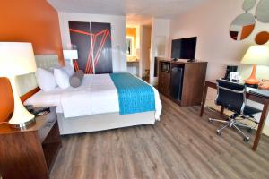 a hotel room with a large bed and a desk at Howard Johnson by Wyndham Ocala FL I-75 in Ocala