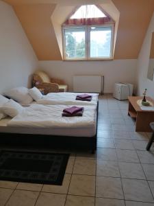 a bedroom with two beds and a window at Centrum Étterem és Panzió in Őriszentpéter