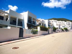 a row of white apartment buildings on a street at Tierra de Irta P B LEK in Peñíscola