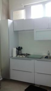 a white kitchen with a stove and a sink at Zen Retreat City Centre in San Juan