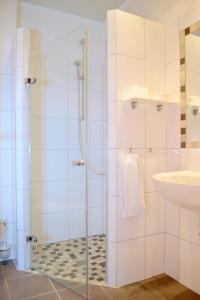 y baño con ducha y lavamanos. en Hotel Herrlichkeit Dornum Janßen, en Dornum