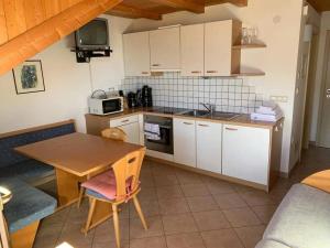 een keuken met witte kasten en een houten tafel bij Santlhof-Chardonnay in Cortaccia
