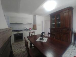 a kitchen with a wooden table with a dog sitting on it at Casa San Quirico Agnone in Agnone