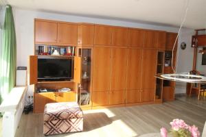 a living room with wooden cabinets and a flat screen tv at Panorama Whg 62, 4 OG in Cuxhaven