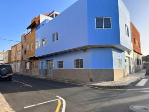 un edificio azul al lado de una calle en Sarah Kite II Vv, Room 2 en Playa del Burrero