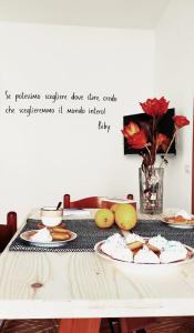 un tavolo con piatti di cibo e un vaso di fiori di Biby's Place a Villaputzu