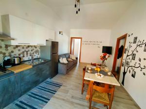 una cucina e un soggiorno con tavolo in una camera di Biby's Place a Villaputzu