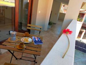 un tavolo con un piatto di cibo e un fiore sopra di Biby's Place a Villaputzu