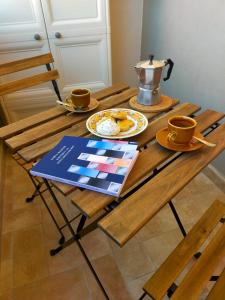 un tavolo di legno con due tazze e una teiera sopra di Biby's Place a Villaputzu