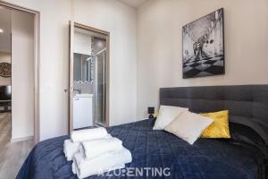 sypialnia z niebieskim łóżkiem i ręcznikami na nim w obiekcie Beautiful Stay - Azurenting w Cannes