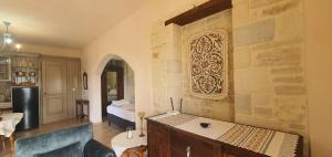 a living room with a stone wall with a refrigerator at Aelia Apartment III in Kamilari +27 photos