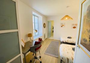 a bedroom with a bed and a desk and a chair at Le Duplex de Bellevue - Futuroscope - La Conciergerie. in Jaunay-Marigny