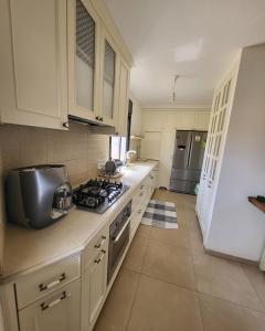 a kitchen with white cabinets and a stove top oven at Luxury duplex Port of Jaffa in Tel Aviv
