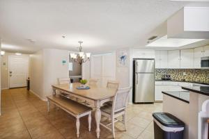 uma cozinha com uma mesa e cadeiras e um frigorífico em Beach Palms- Unit 102 em Clearwater Beach