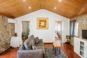 a living room with a couch and a tv at Forno House - A Cabana in Vila Praia de Âncora