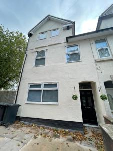 a white house with a black door at Lovely 1 bed Studio Apartment 