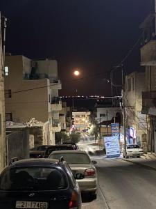 a city street at night with cars parked on the street at MiaDabia Supreme in Madaba