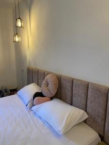 una mujer sentada en una cama con dos almohadas en MiaDabia Supreme, en Madaba