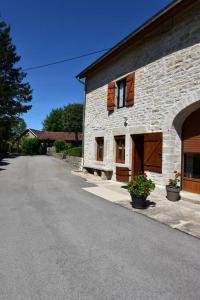 a stone building with a road in front of it at Gîte HAUTEROCHE BOISSON in Crançot