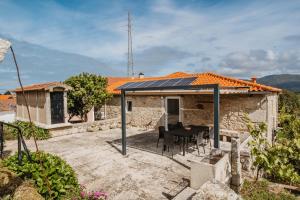 a house with a black table and chairs in front of it at Forno House - A Cabana in Vila Praia de Âncora
