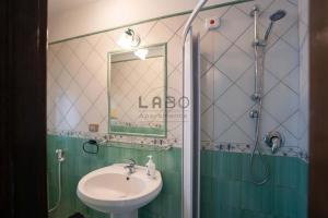ein Bad mit einem Waschbecken und einer Dusche mit einem Spiegel in der Unterkunft Choros in Tropea