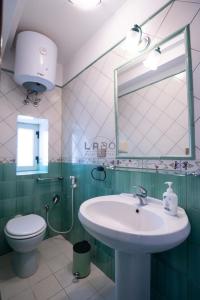 ein Badezimmer mit einem Waschbecken, einem WC und einem Spiegel in der Unterkunft Choros in Tropea