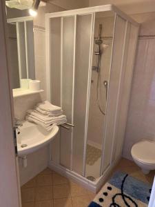 een witte badkamer met een douche en een wastafel bij Santlhof-Chardonnay in Cortaccia