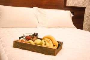 ein Obsttablett aus Holz auf dem Bett in der Unterkunft Esposizione Boutique in Rom