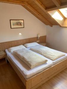 een slaapkamer met een groot bed met witte lakens bij Santlhof-Chardonnay in Cortaccia