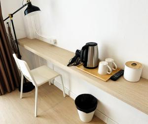 a counter with a coffee maker and a chair on it at River Home Bangkok in Bangkok