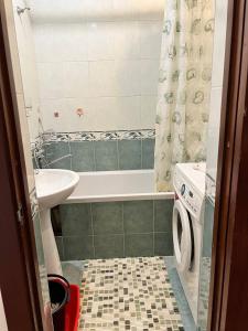 La salle de bains est pourvue d'une baignoire, d'un lavabo et d'un lave-linge. dans l'établissement Квартира в центре, à Tachkent