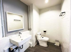 a white bathroom with a sink and a toilet at River Home Bangkok in Bangkok
