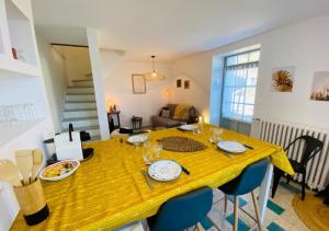 a dining room with a yellow table and chairs at Le Duplex de Bellevue - Futuroscope - La Conciergerie. in Jaunay-Marigny