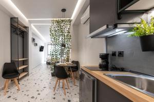 a kitchen with a sink and a table with chairs at Furla Suites Athens in Athens