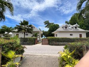 a house with a fence and a driveway at Digwa Beach Chalet in La Digue