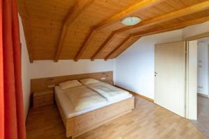 ein Schlafzimmer mit einem Bett und einer Holzdecke in der Unterkunft Santlhof-Weissburgunder in Kurtatsch