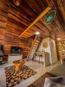 ein Wohnzimmer mit einer Holzdecke und einem Tisch in der Unterkunft Cabanas do Valle in Itaara