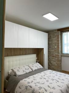 a bedroom with a large bed and a brick wall at Casa la Rosa in Gubbio