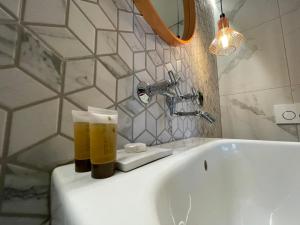a bathroom with a sink with a glass of beer on it at Central place with lake view in Šiauliai